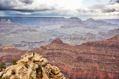 Rock formations on landscape against cloudy sky