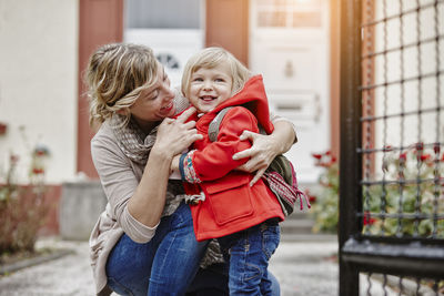 Mother with daughter at house entrance