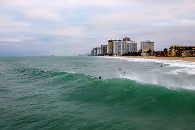 Scenic view of sea and buildings against sky