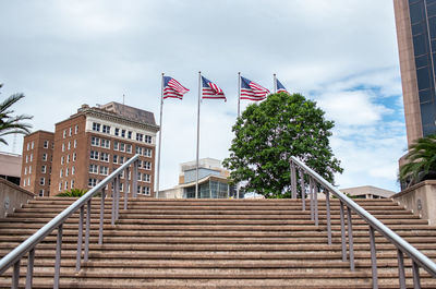 Low angle view of flag by building against sky