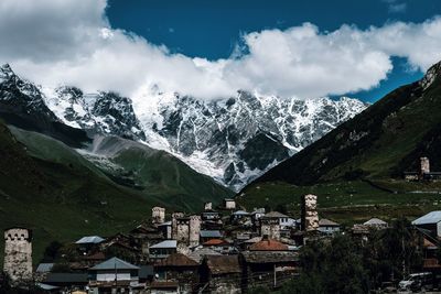 Panoramic view of townscape and mountains against sky