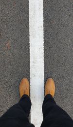 Low section of man standing on road