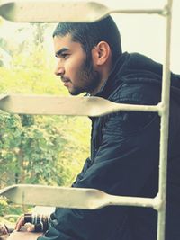 Side view of young man standing outdoors