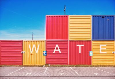 Text on colorful cargo containers at harbor