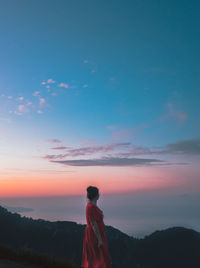 Side view of woman standing sky during sunset