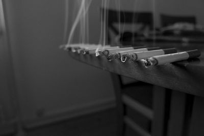 Close-up of cigarette smoking on railing