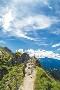 Narrow pathway along countryside landscape