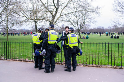 Group of people standing on street amidst trees