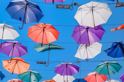 Low angle view of umbrellas hanging against sky