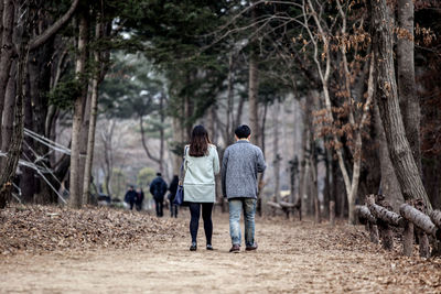 Rear view of man and woman walking on road