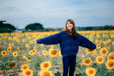 Smiling young woman standing in sunflower field