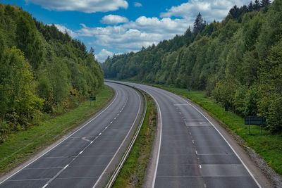 Road amidst trees against sky