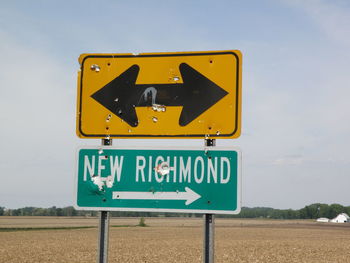 Close-up of road sign against sky