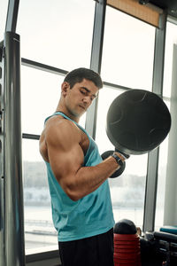 Shirtless man exercising in gym