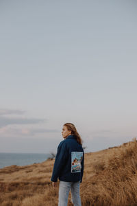 Full length of woman standing on land against sky