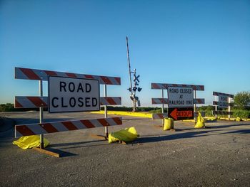 Barricades on road against clear blue sky