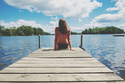 Rear view of woman on pier against lake