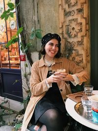 Portrait of a smiling young woman sitting at restaurant