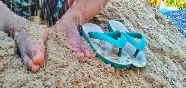 High angle view of hands on sand at beach