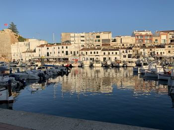 Boats moored at harbor against buildings in city