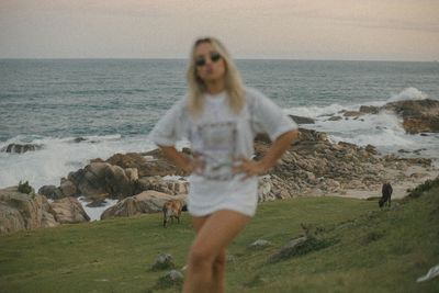 Portrait of young woman standing on field