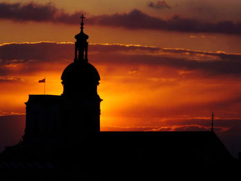 Silhouette of church against cloudy sky