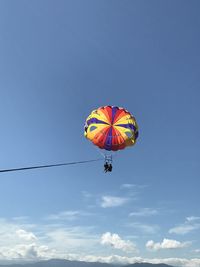 Low angle view of person paragliding against sky