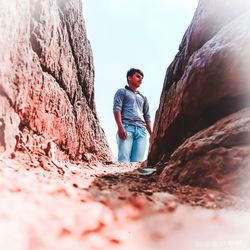 Full length of young man standing on rock