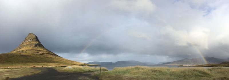 Panoramic view of rainbow over landscape against sky