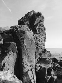 Rock formation on beach against sky