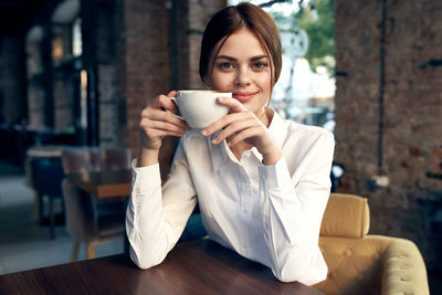 Portrait of young woman drinking coffee