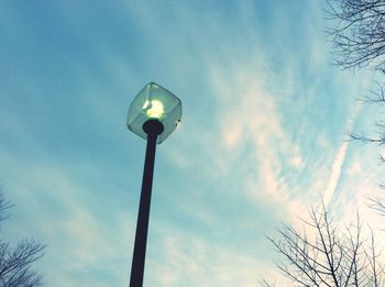 Low angle view of bare tree against cloudy sky