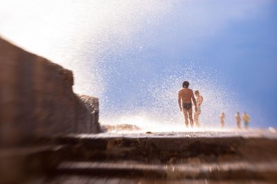 Man and woman enjoying at beach against sky