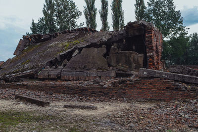 Old ruin by trees against sky