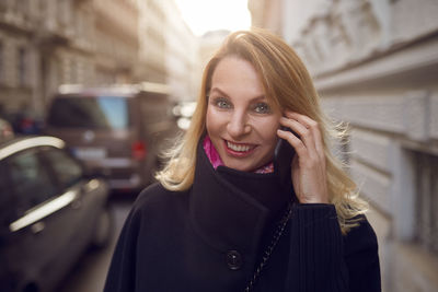 Portrait of smiling young woman using mobile phone