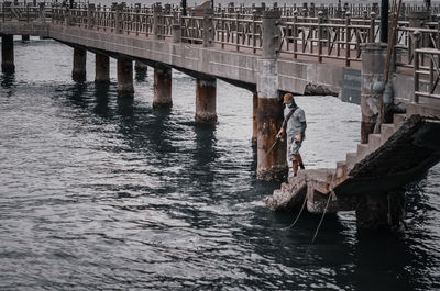 Man on wooden bridge over river