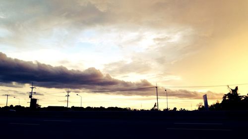 Silhouette of trees against cloudy sky