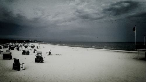 Scenic view of beach against cloudy sky