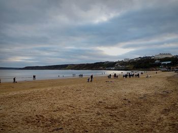Group of people on beach against sky