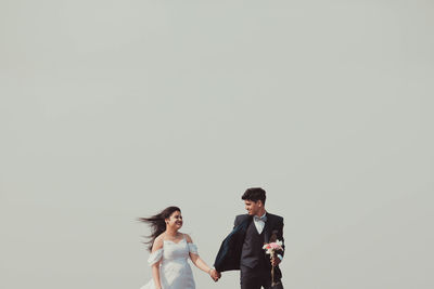 Young couple standing against white background