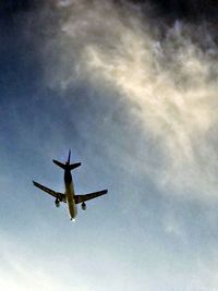 Low angle view of airplane flying against sky