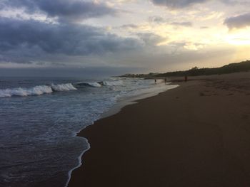 View of beach against cloudy sky