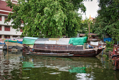 Boats moored in river against trees