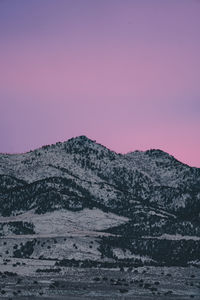 Scenic view of snowcapped mountains against clear sky during sunset