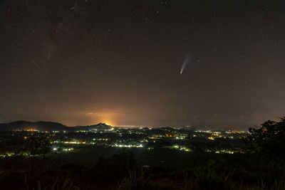 Illuminated city against sky at night