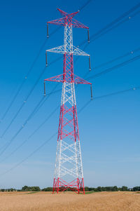 Electricity pylon on field against sky