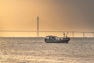 View of suspension bridge over sea against sky