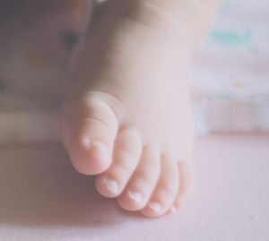 Low section of baby on bed