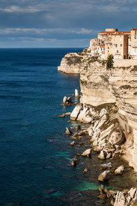 Rock formations by sea against sky