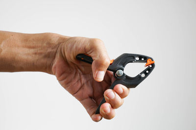 Close-up of man holding hands against white background